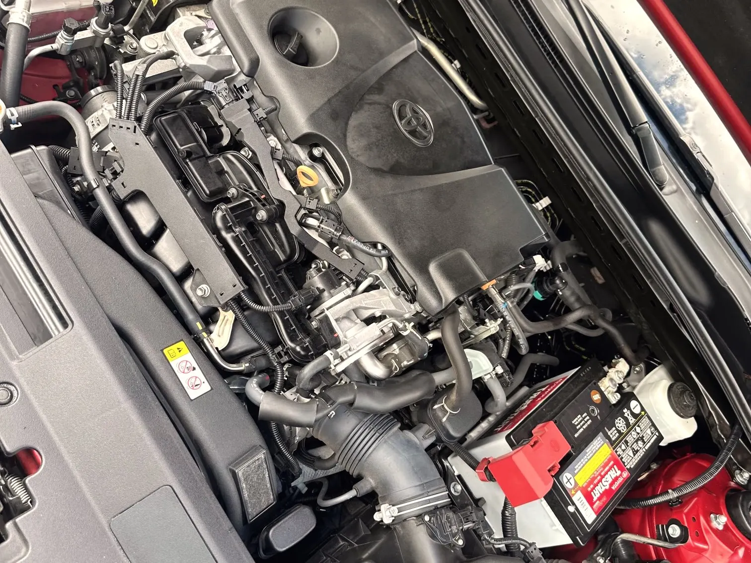 Engine bay of a red Toyota Camry, cleaned and serviced